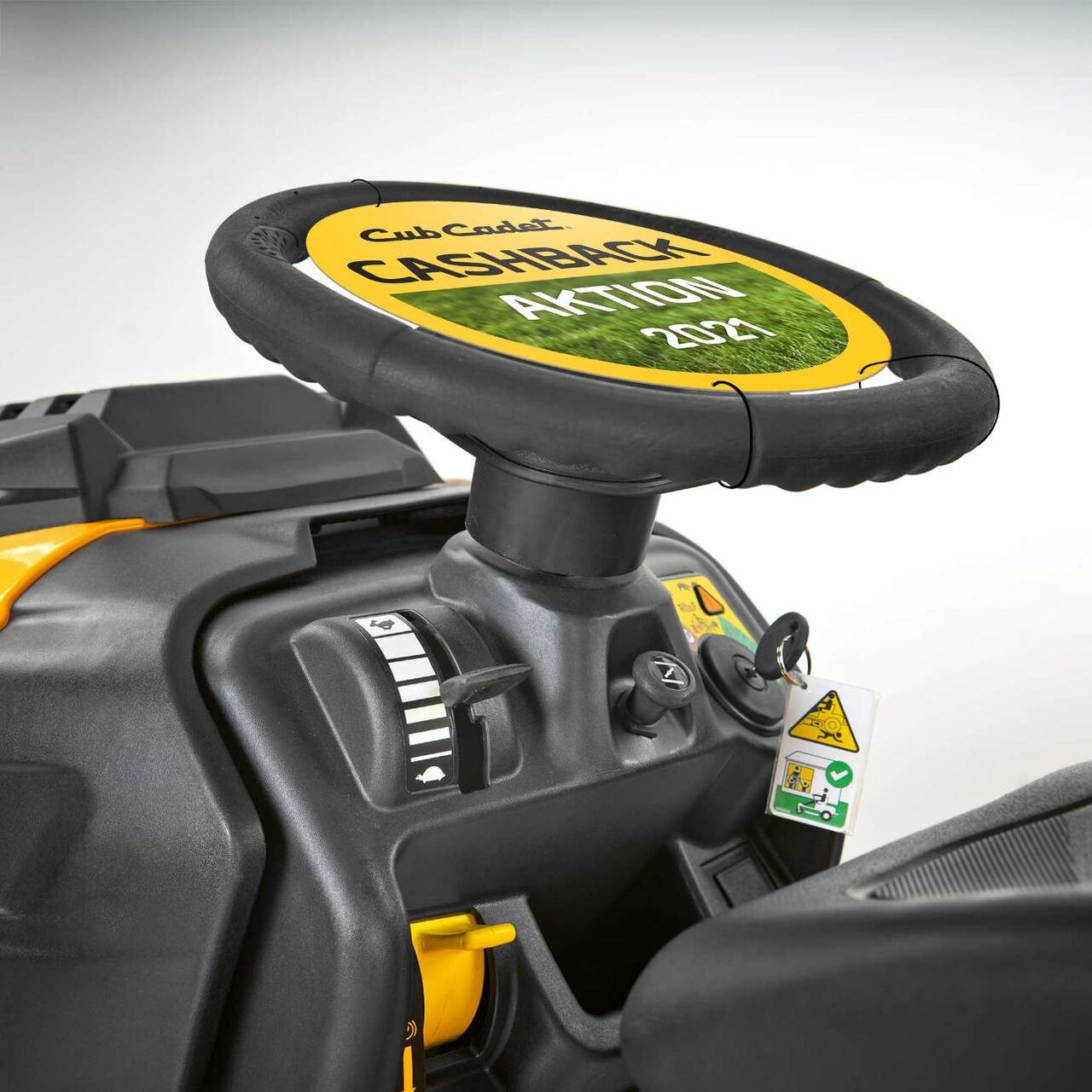 Nahaufnahme des Lenkrads und der Bedienelemente eines Cub Cadet Rasentraktors mit Markenlogo.