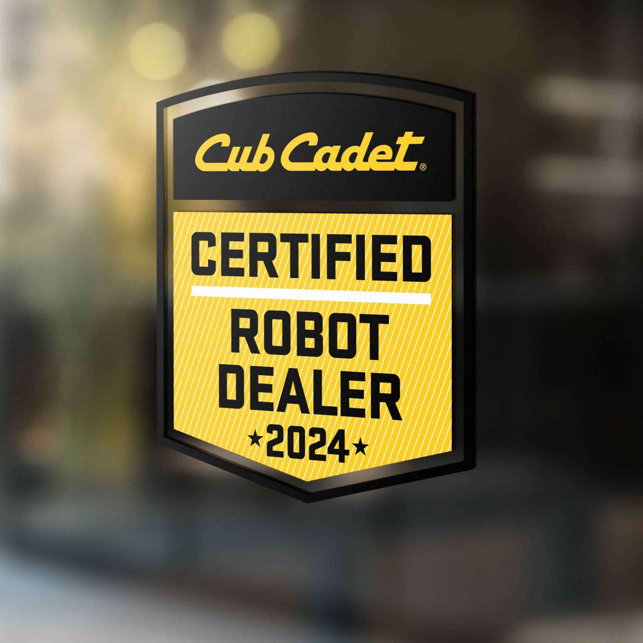 Cub Cadet Aufkleber „Certified Robot Dealer 2024“ auf Glasscheibe – schwarz-gelbes Qualitätssiegel.